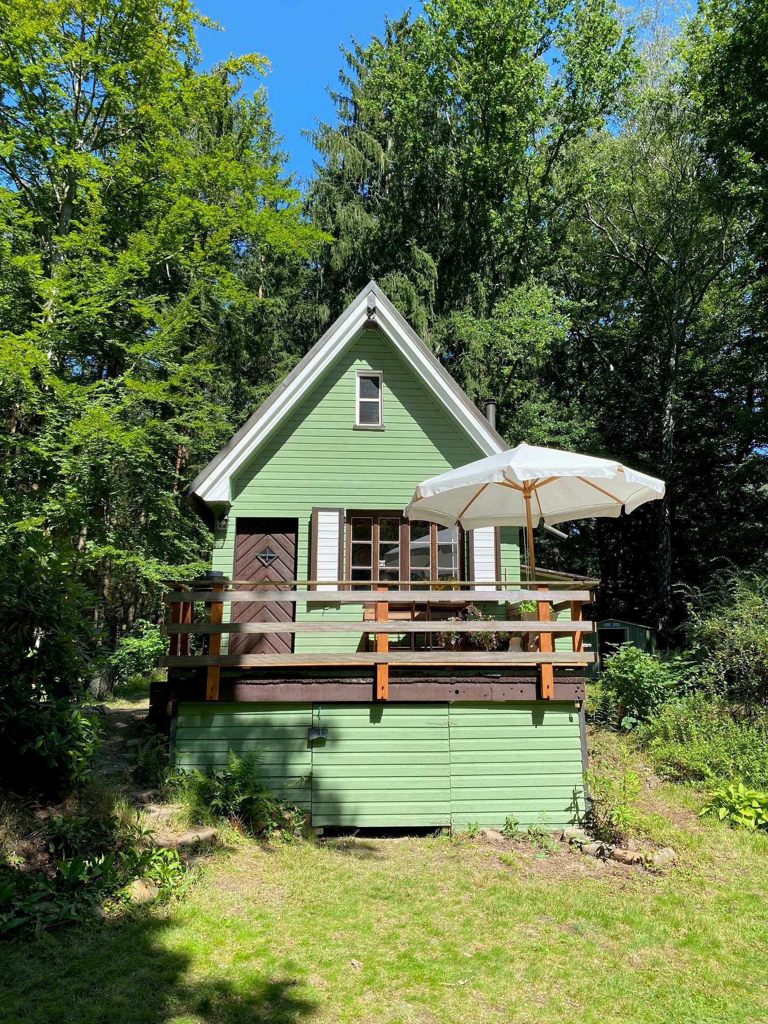 Groen houten huis met witte luiken